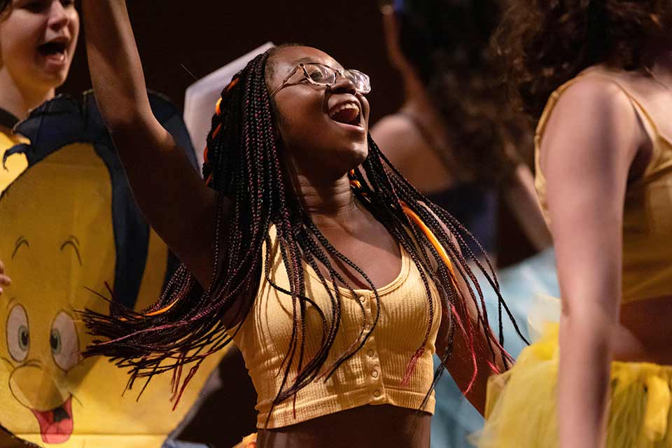 Students in yellow on stage