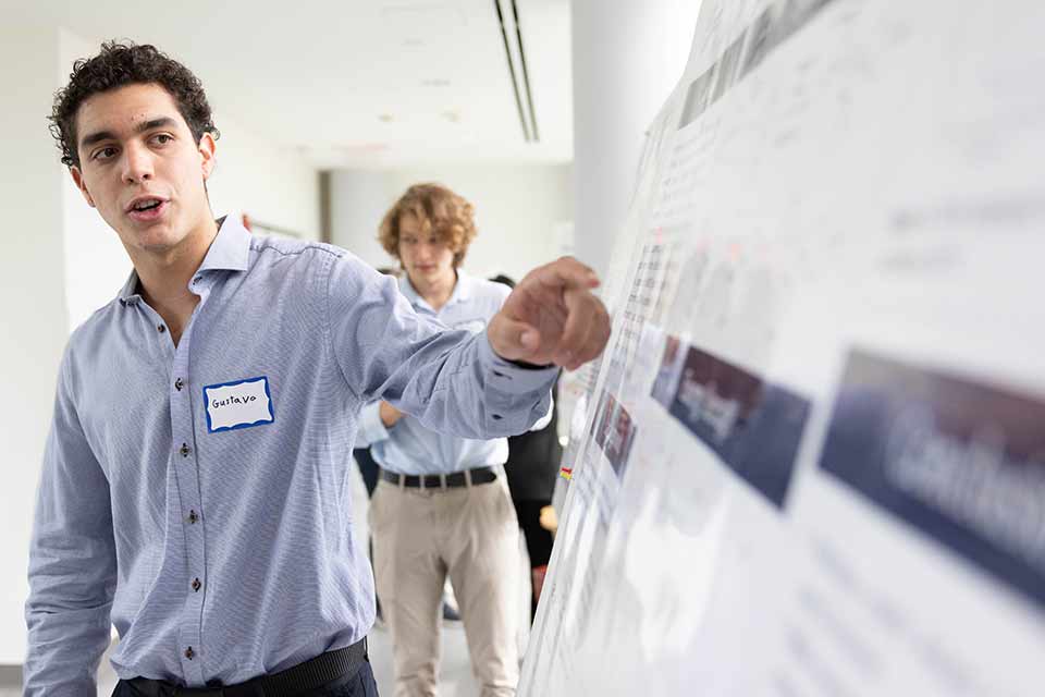 Gustavo Sigelmann ’25 presents his work to fellow students during SciFest