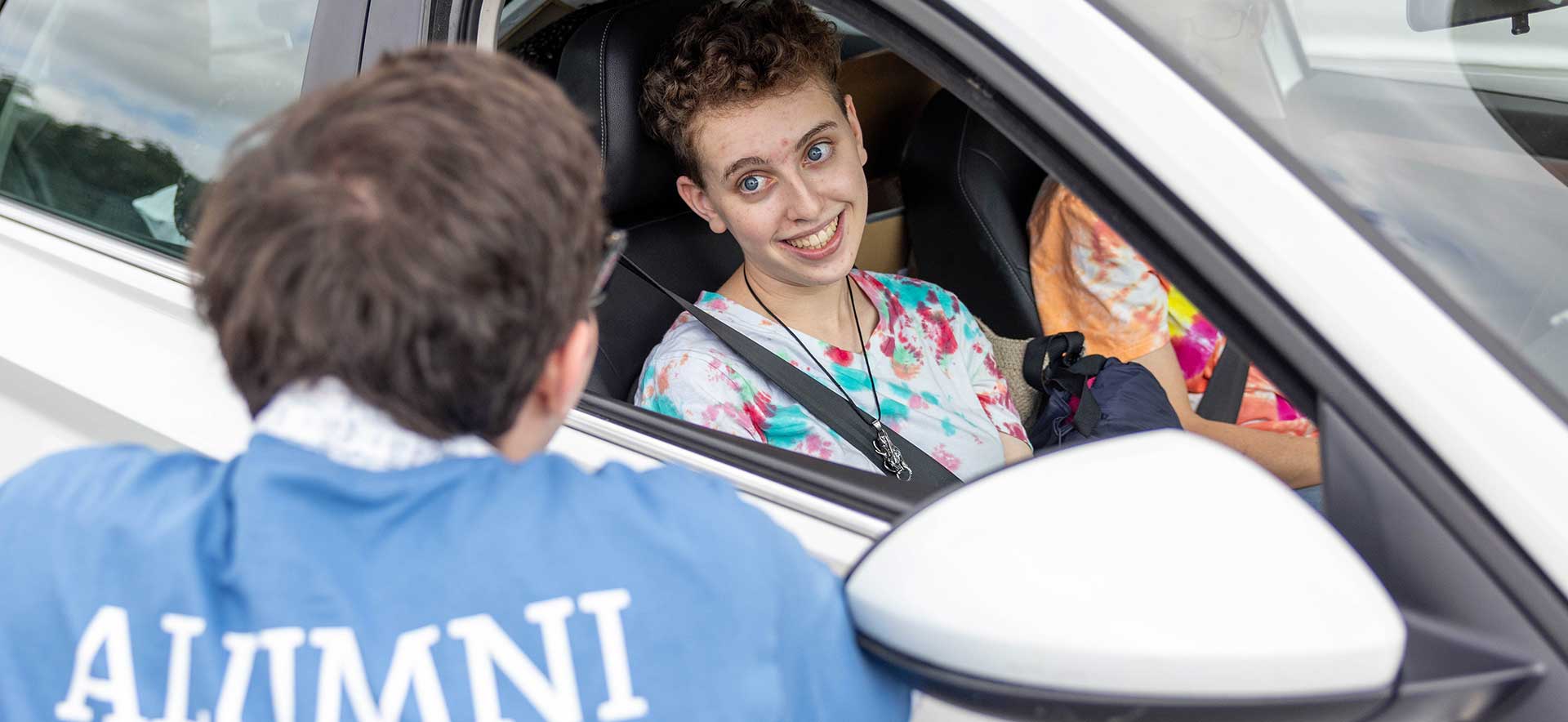 A new student speaks to a person wearing an ALUMNI shirt