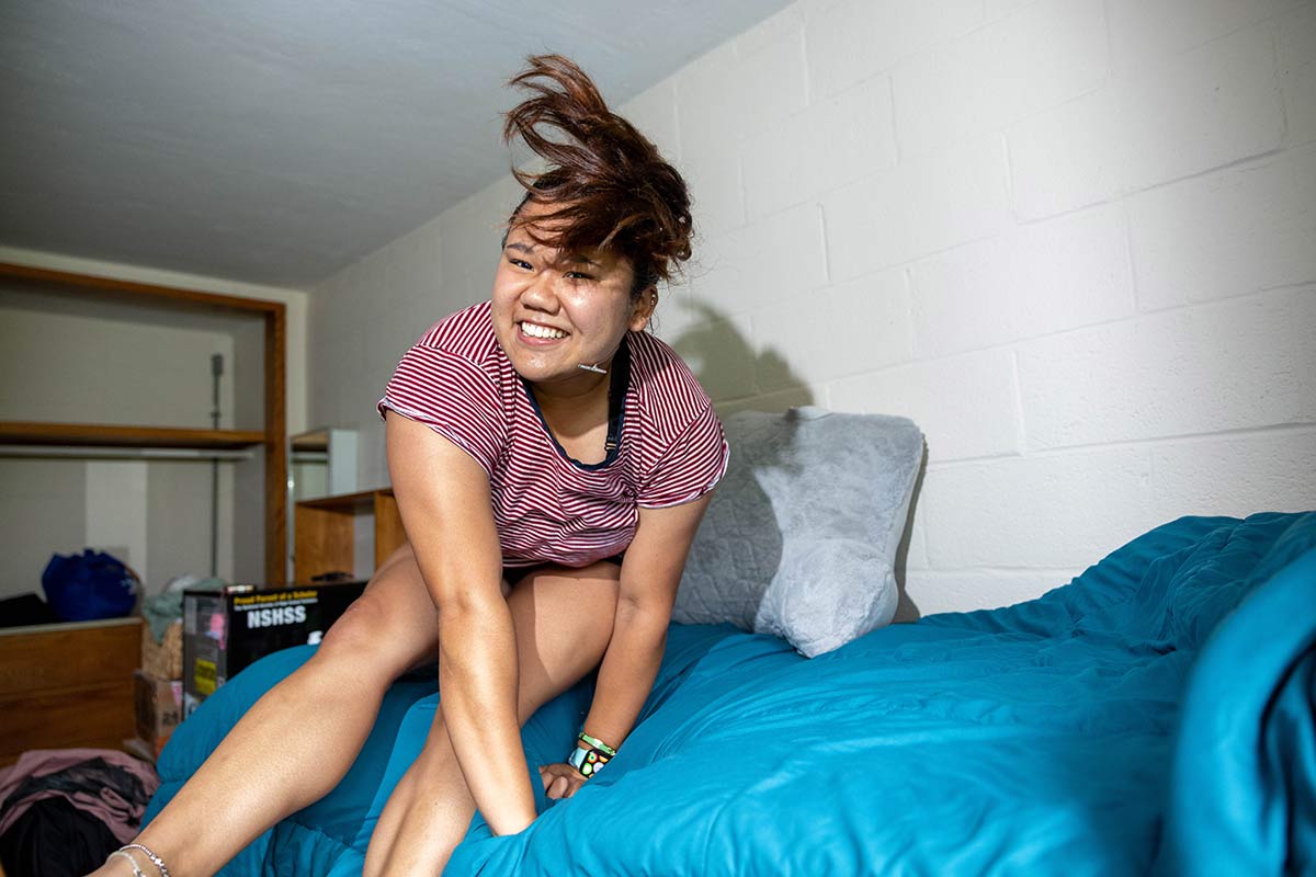 Student jumping on a bed