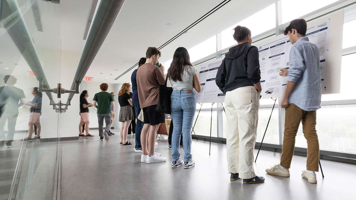 Students engaging with posters at SciFest