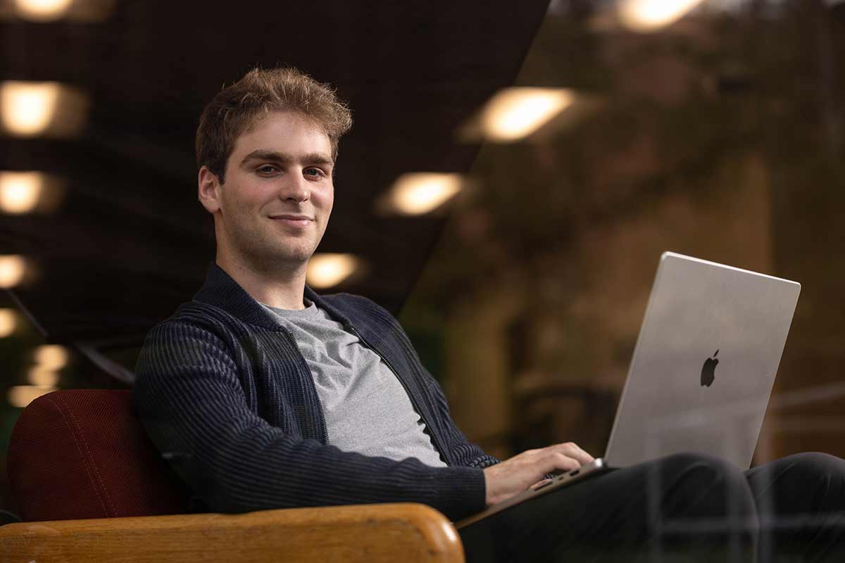 Ephraim Zimmerman seated with a laptop computer