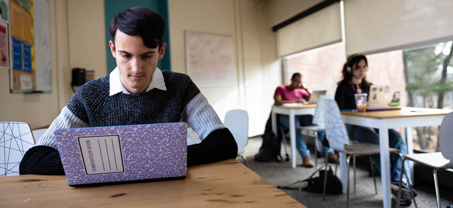 Cameron and other students work on their laptops