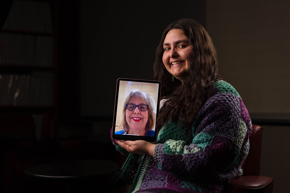 Jessie holds an iPad with her grandmother on it