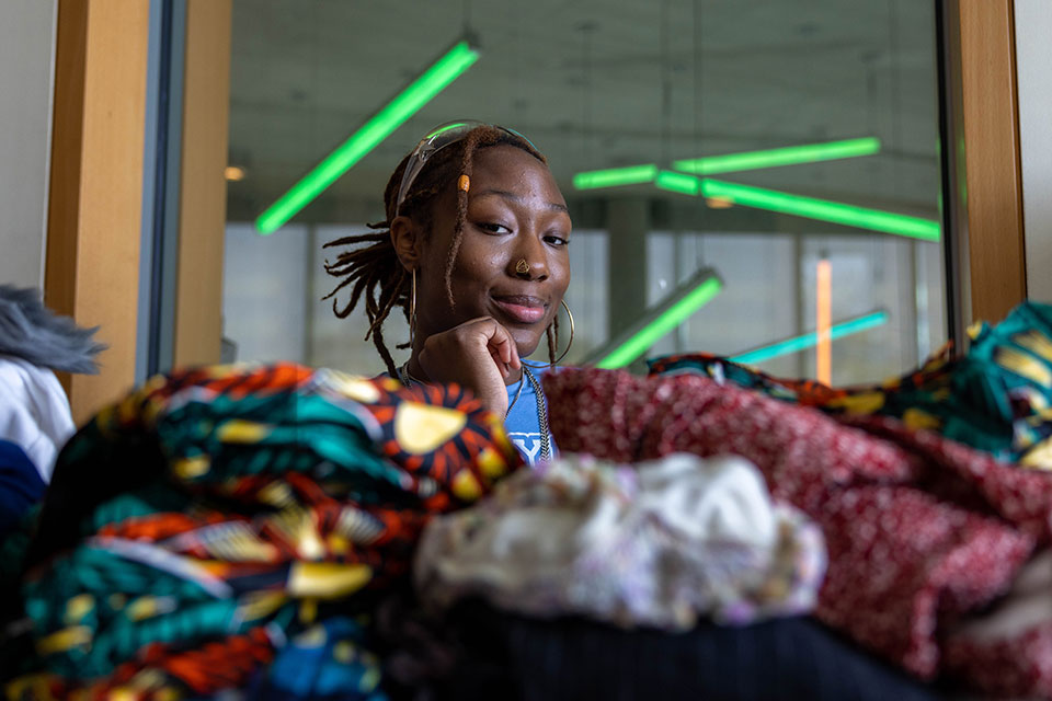 Mazzi Ingram poses with a pile of clothing.