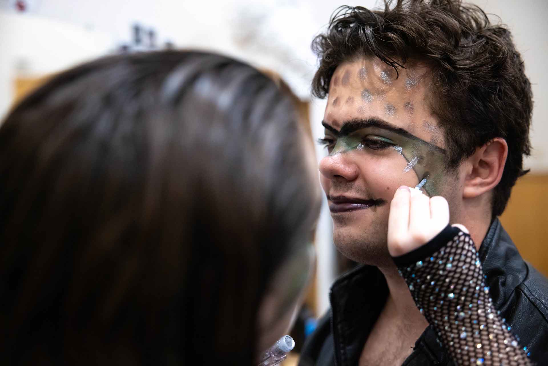 A person applying facepaint to another person
