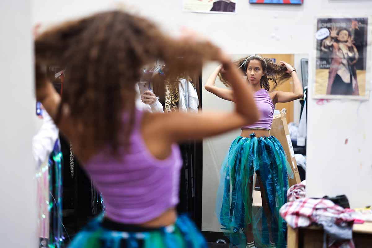 Person looking in the mirror adjusting their hair