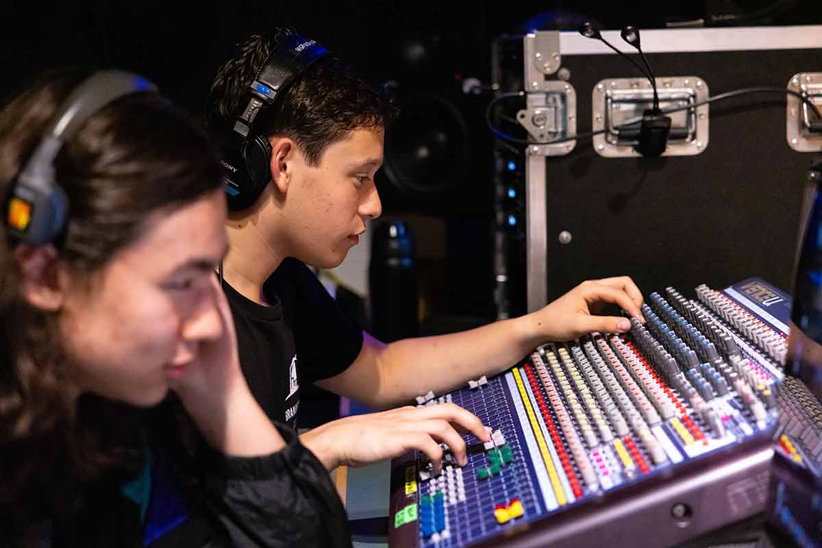 Two sound technicians operating a sound board