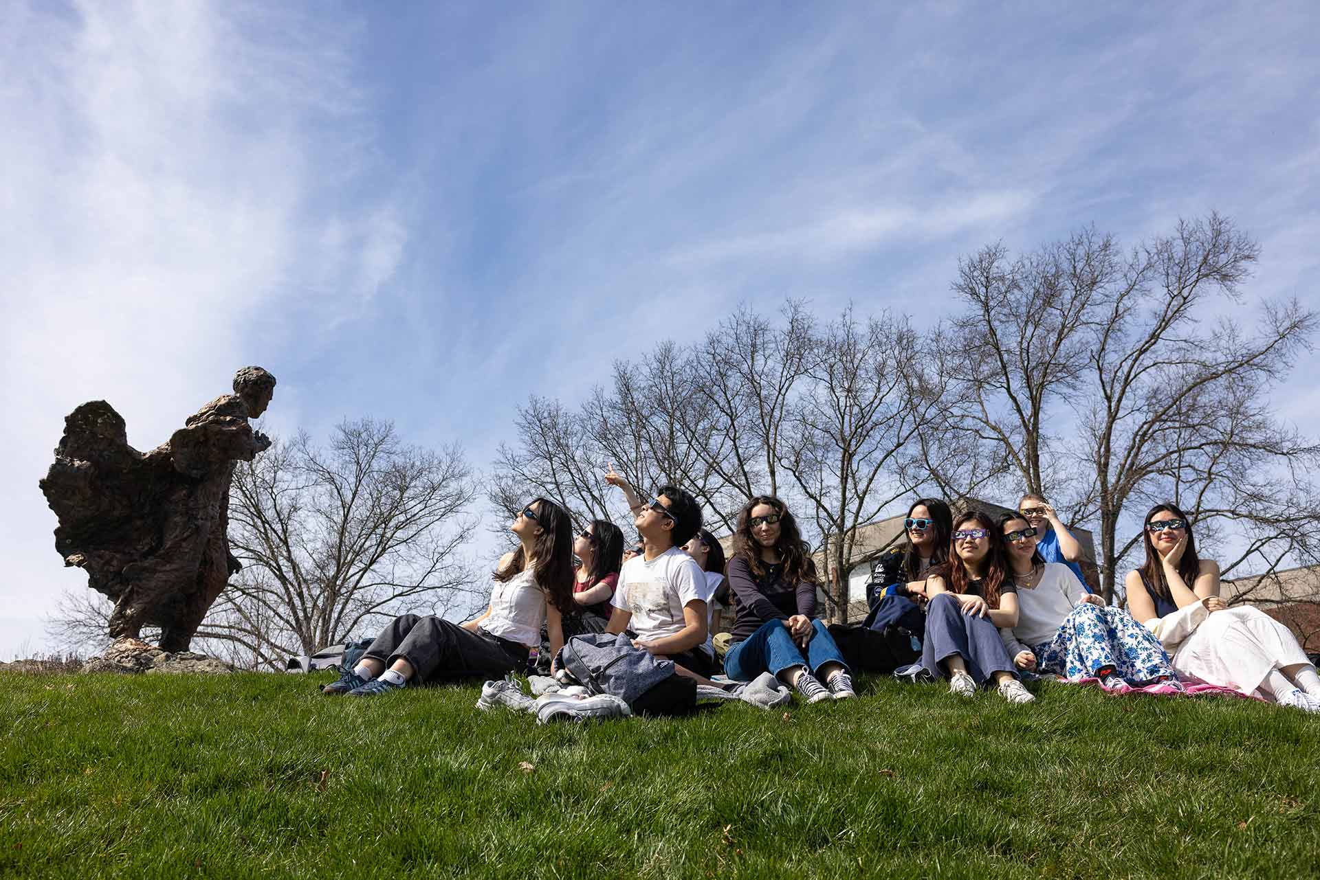 Group of students seated next to the Brandeis statue