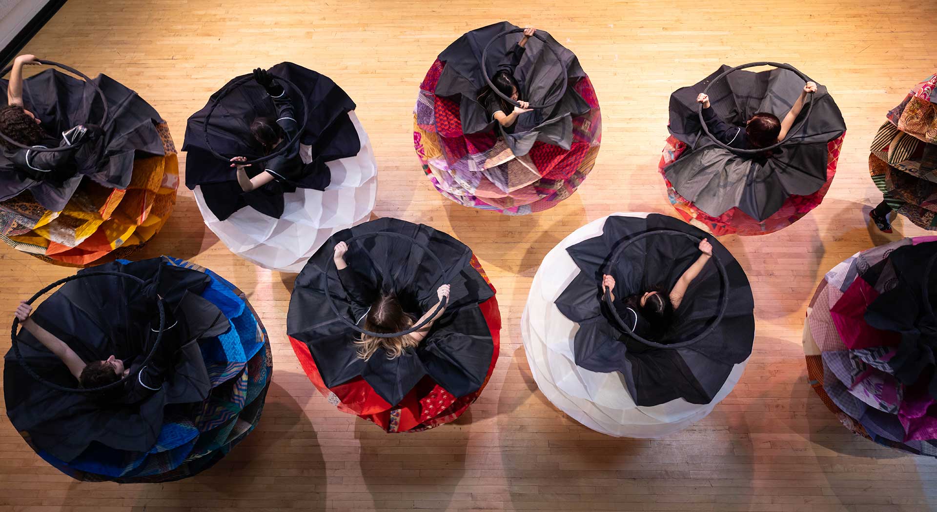 Aerial view of dancers in costumes spinning in a circular formation.