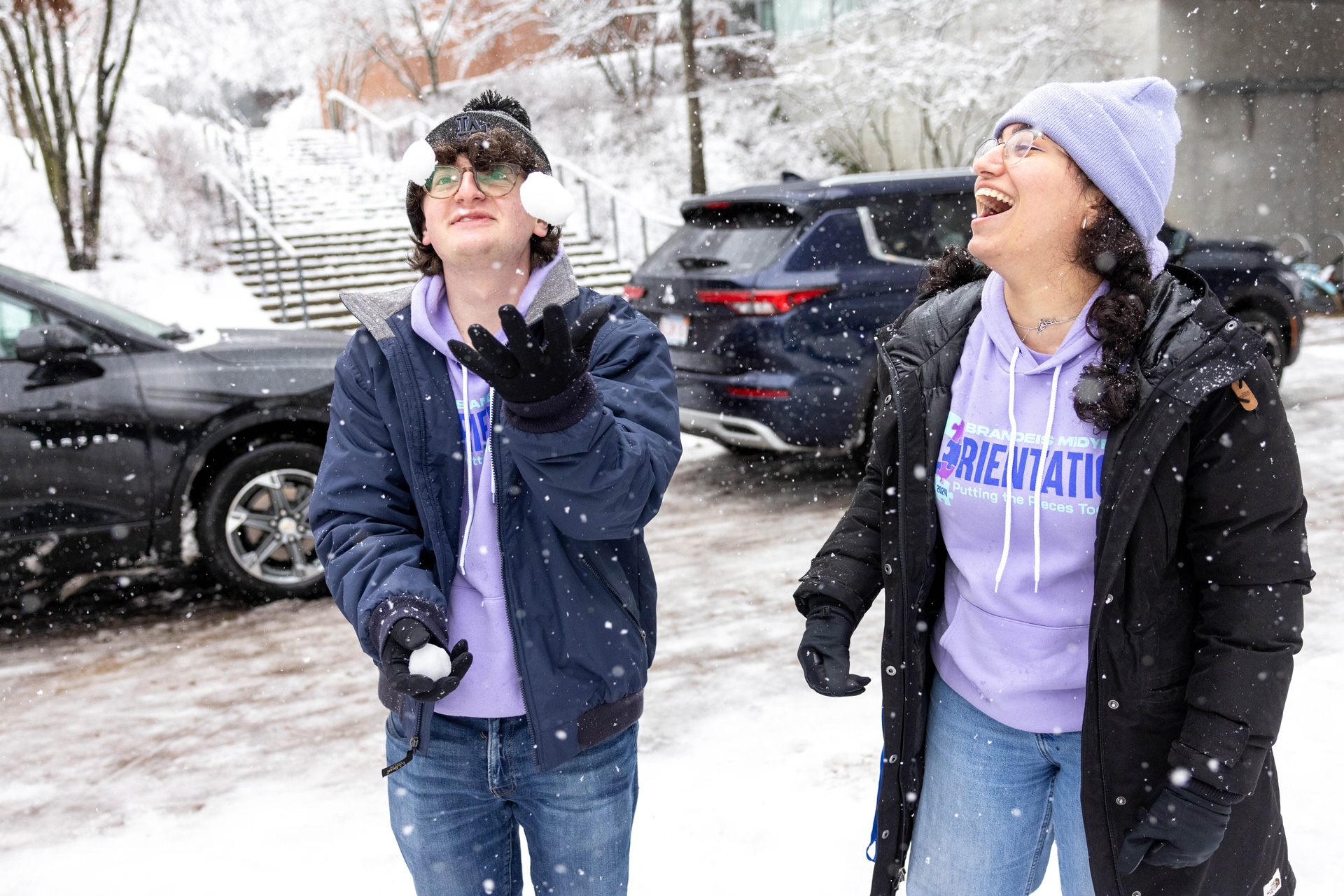 Students juggling snowballs and laughing