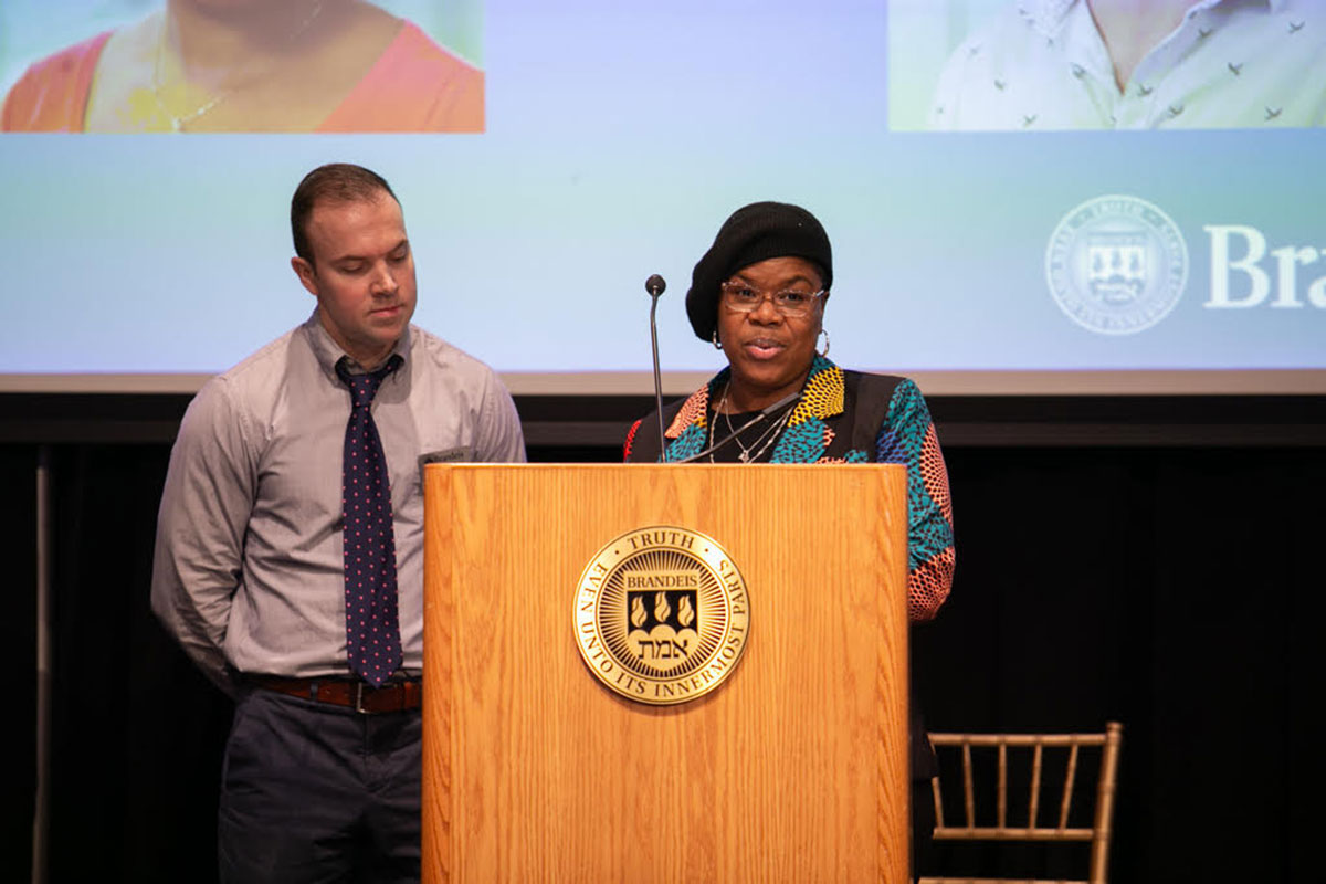 Kathryn A. Bethea-Rivera speaks at a podium as Karl LaClair looks on