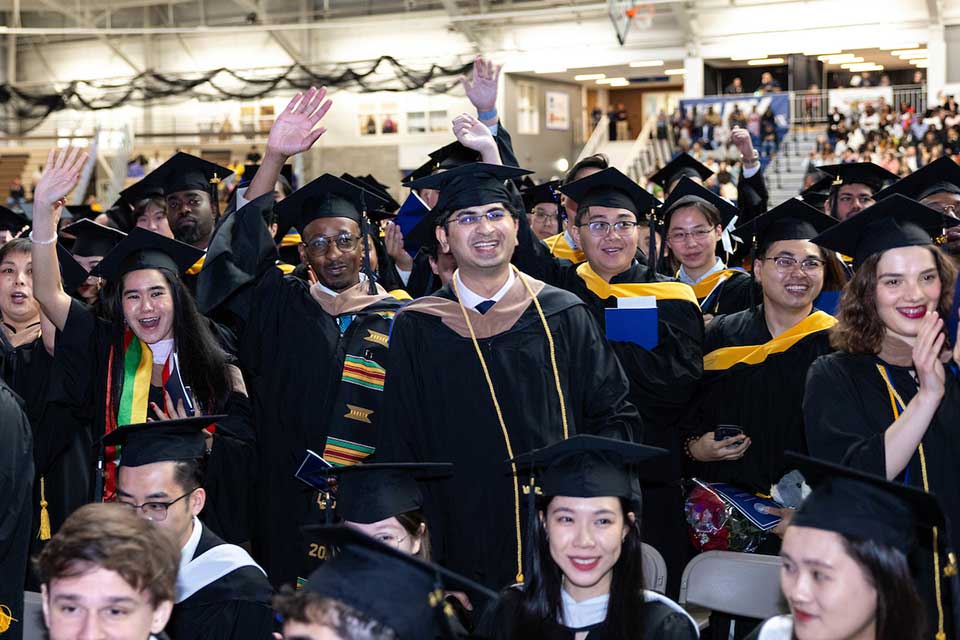 Graduates in caps and gowns celebrating at Commencement