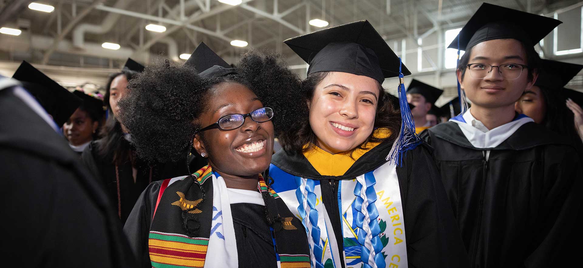 Graduates in caps and gowns smile during the Undergraduate Commencement ceremony