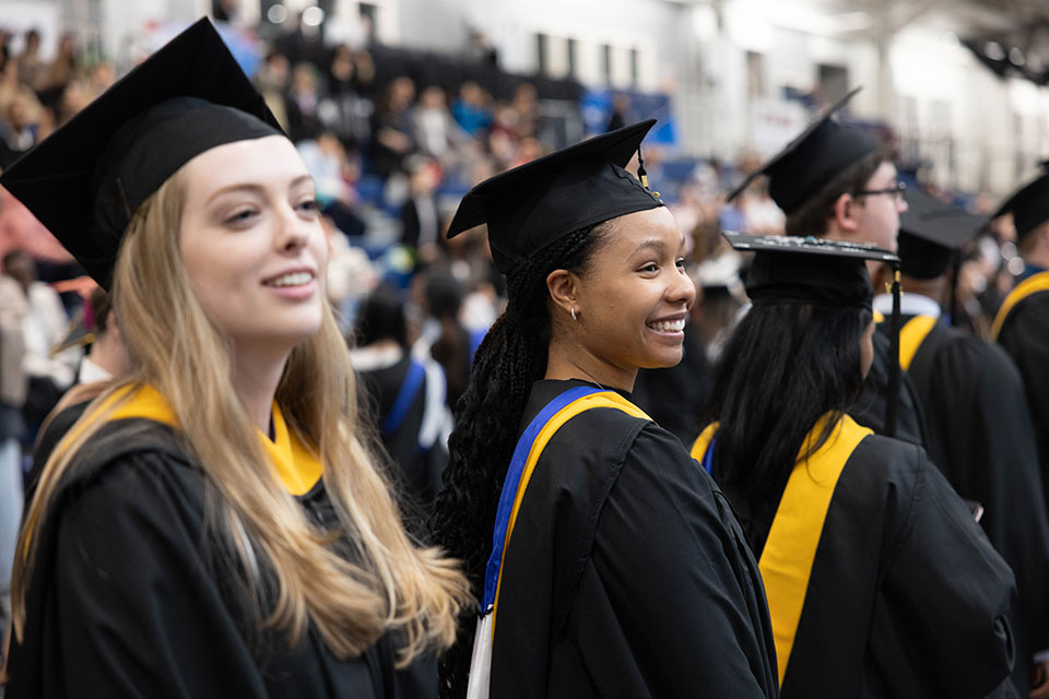 Graduates in caps and gowns stand in line during the Commencement Ceremony