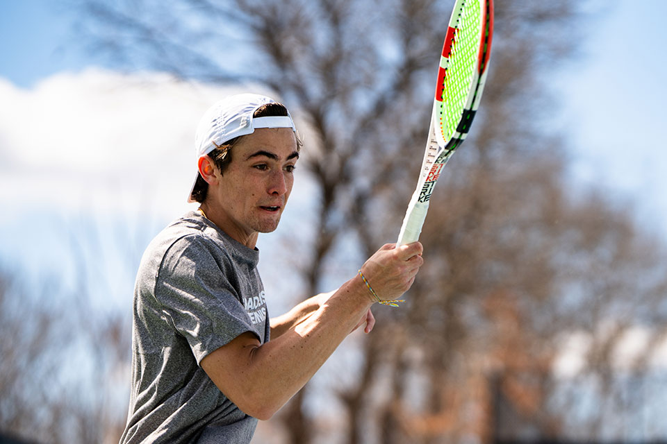 A tennis player swings a tennis racquet.