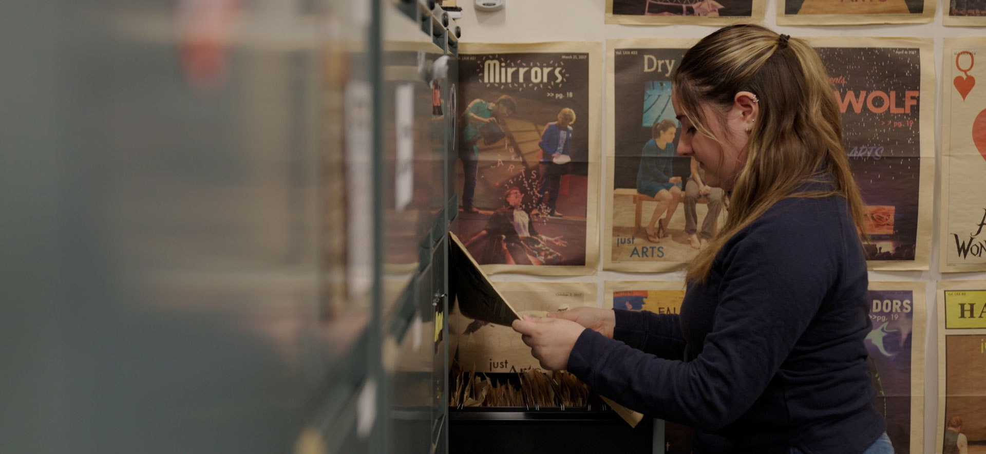 Anna Martin looking at documents in a filing cabinet.
