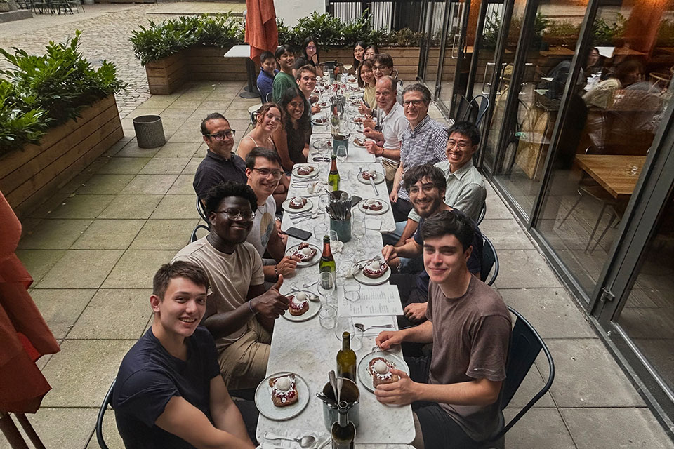 A group of people eating dinner at a table in a restaurant.