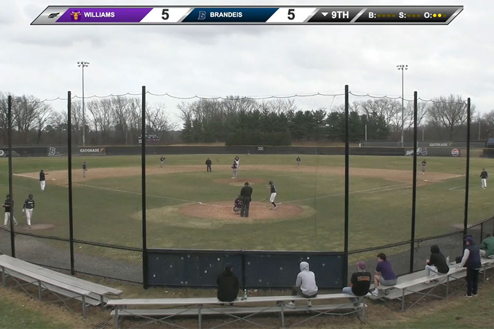 Athletes play baseball on a field.