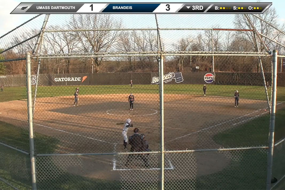 Athletes play softball on a field.
