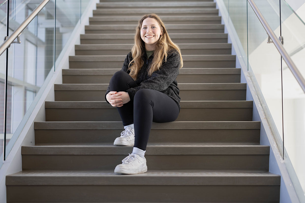 Sheindl Spitzer-Tilchin sits on a staircase.