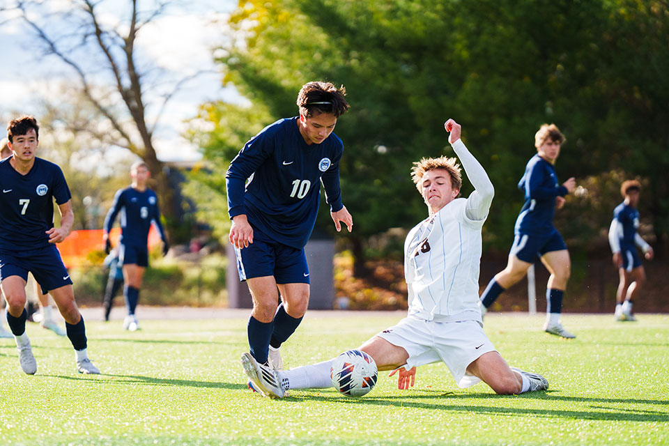 Rainer O. ’26 weaves past a Tufts midfielder in the second round the NCAA tournament.