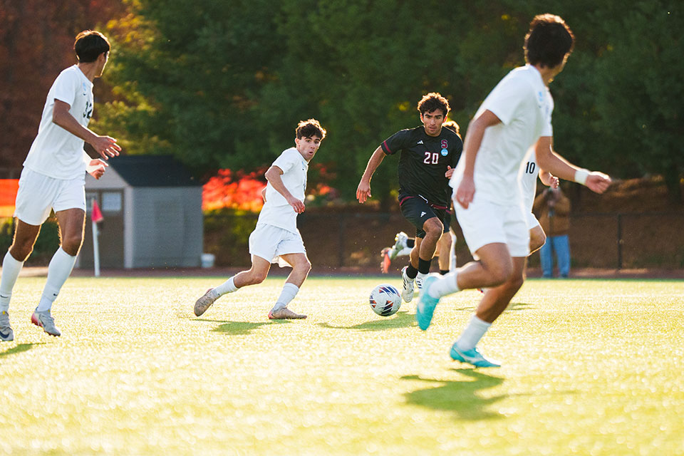 Nico B. ’26 passes the ball around a Stevens player to Aidan C. ’27.