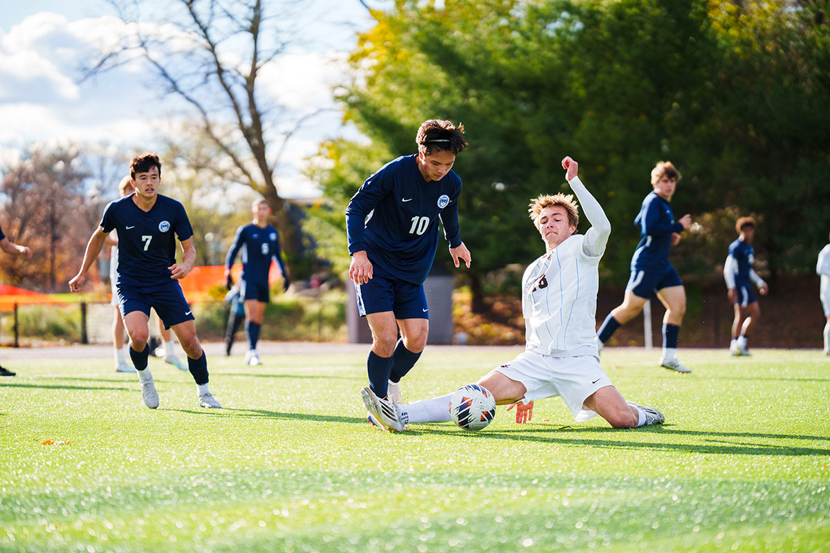 Rainer O. ’26 weaves past a Tufts midfielder in the second round the NCAA tournament.