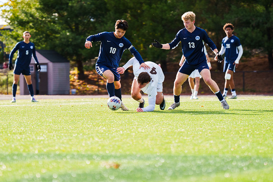 Rainer Osselmann-Chai ’26, left, and Slater Loffredo ’26 win the ball away from a Tufts player.