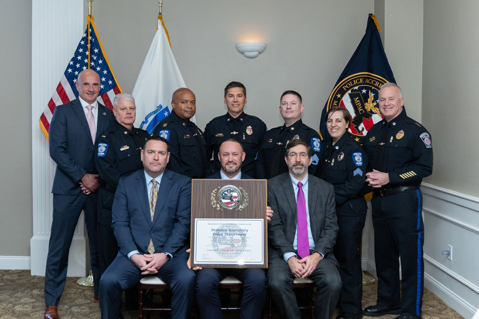 Brandeis police officers, one holding a plaque