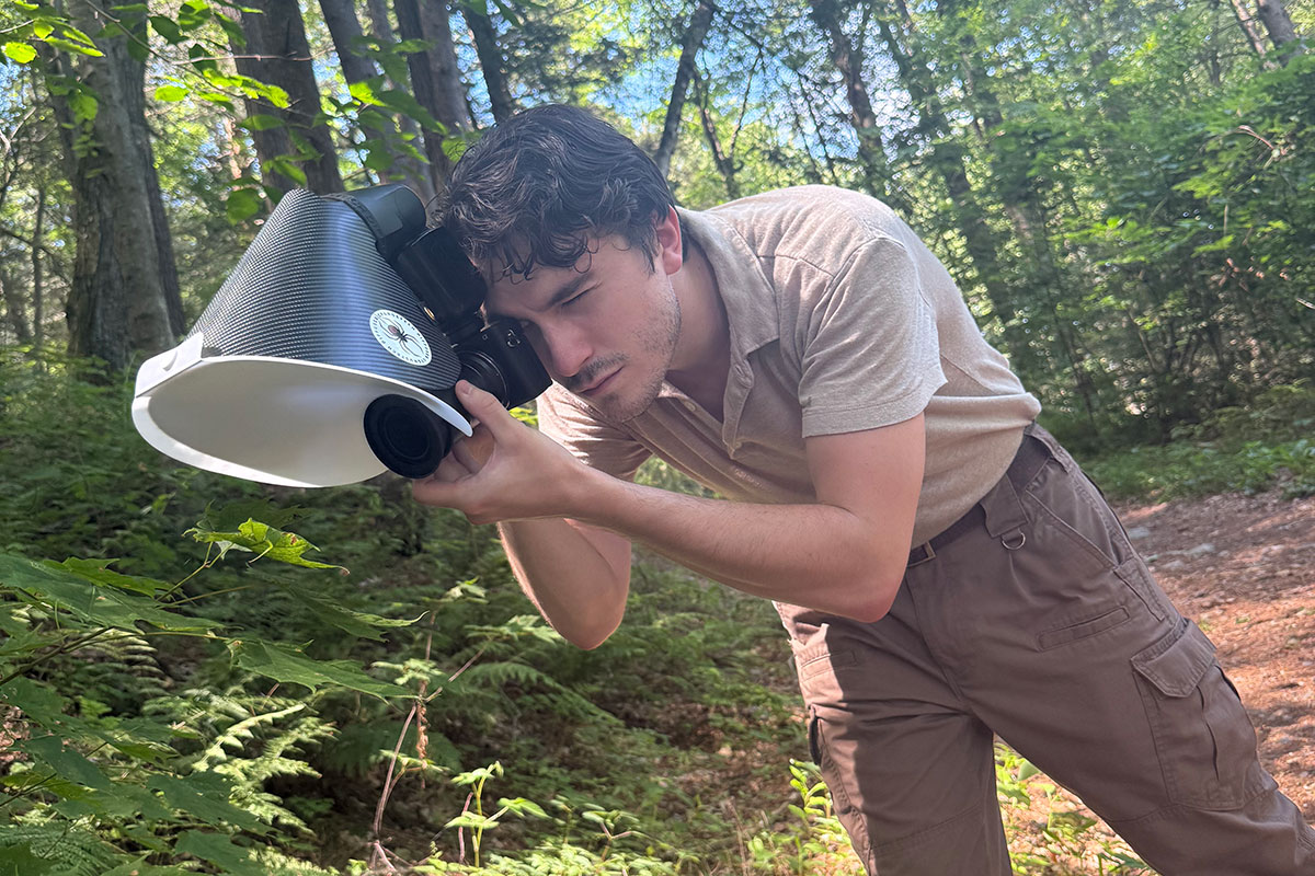 Jack Forrester taking a photograph in the forest.