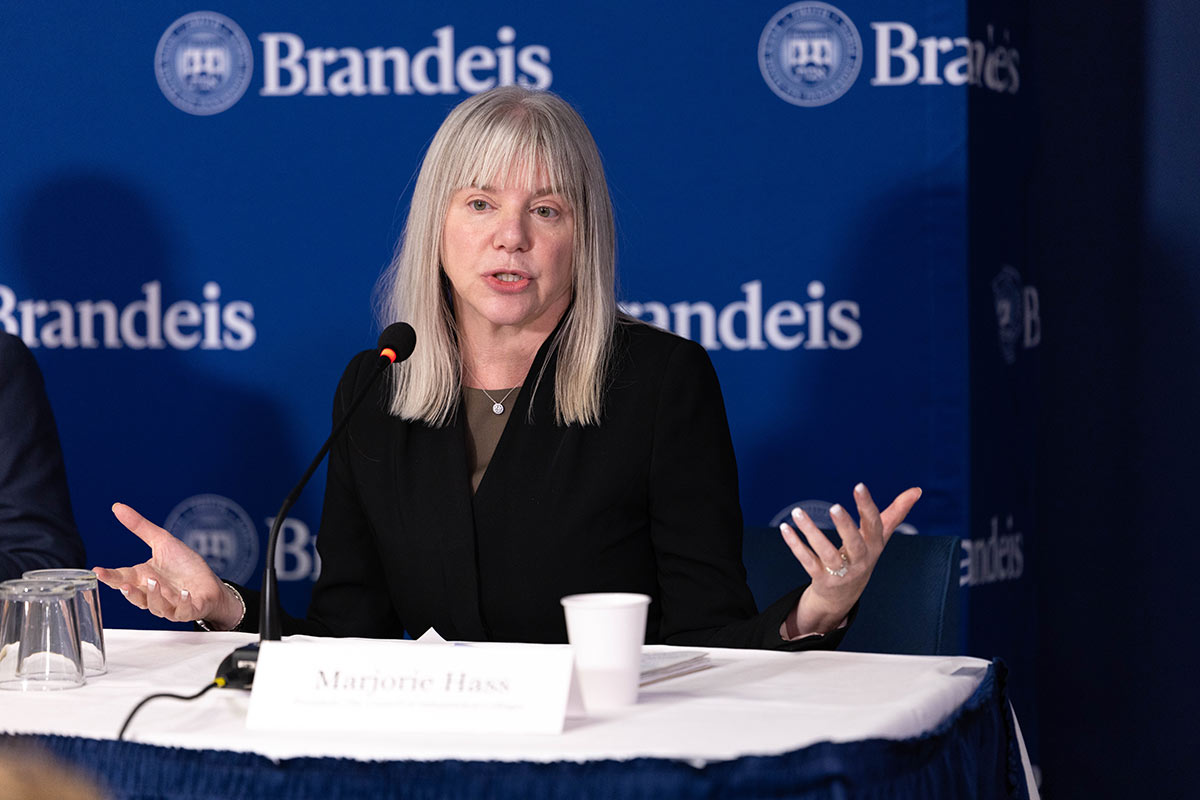 Marjorie Hass speaking with a Brandeis backdrop in the background