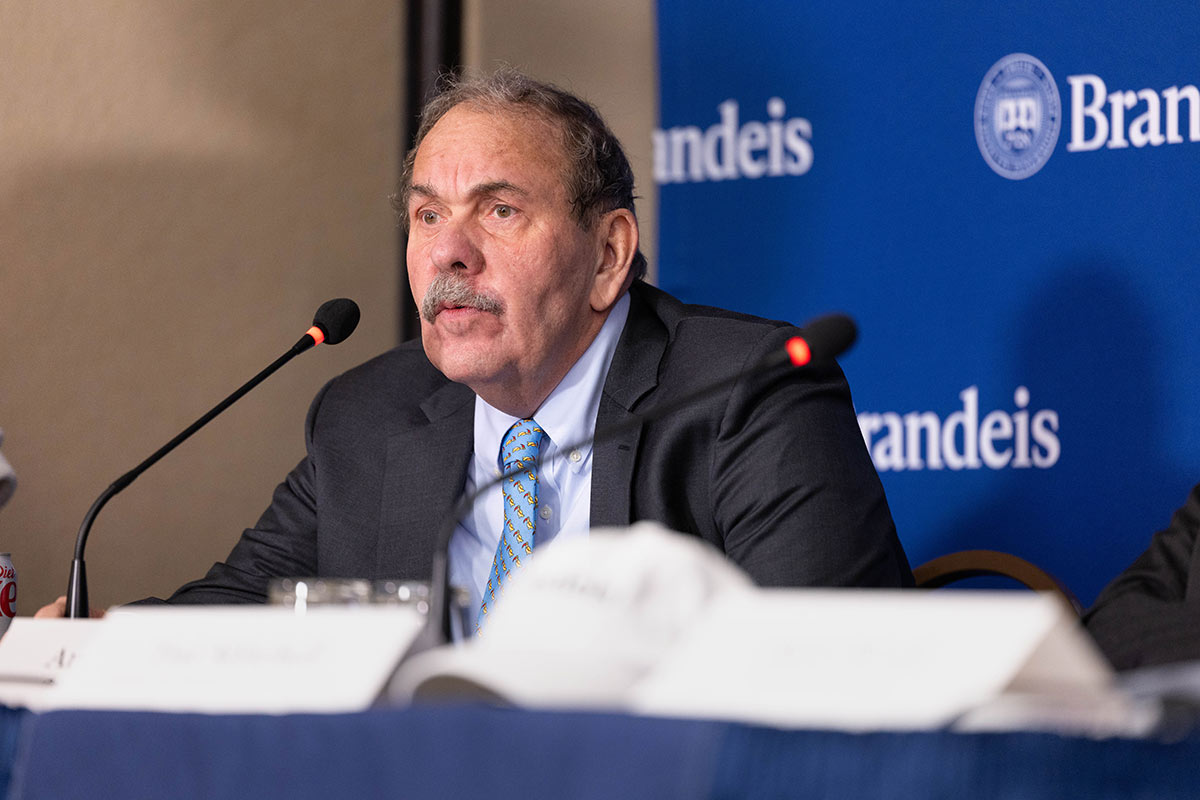 Brandeis President Arthur Levine smiling with a Brandeis backdrop behind him
