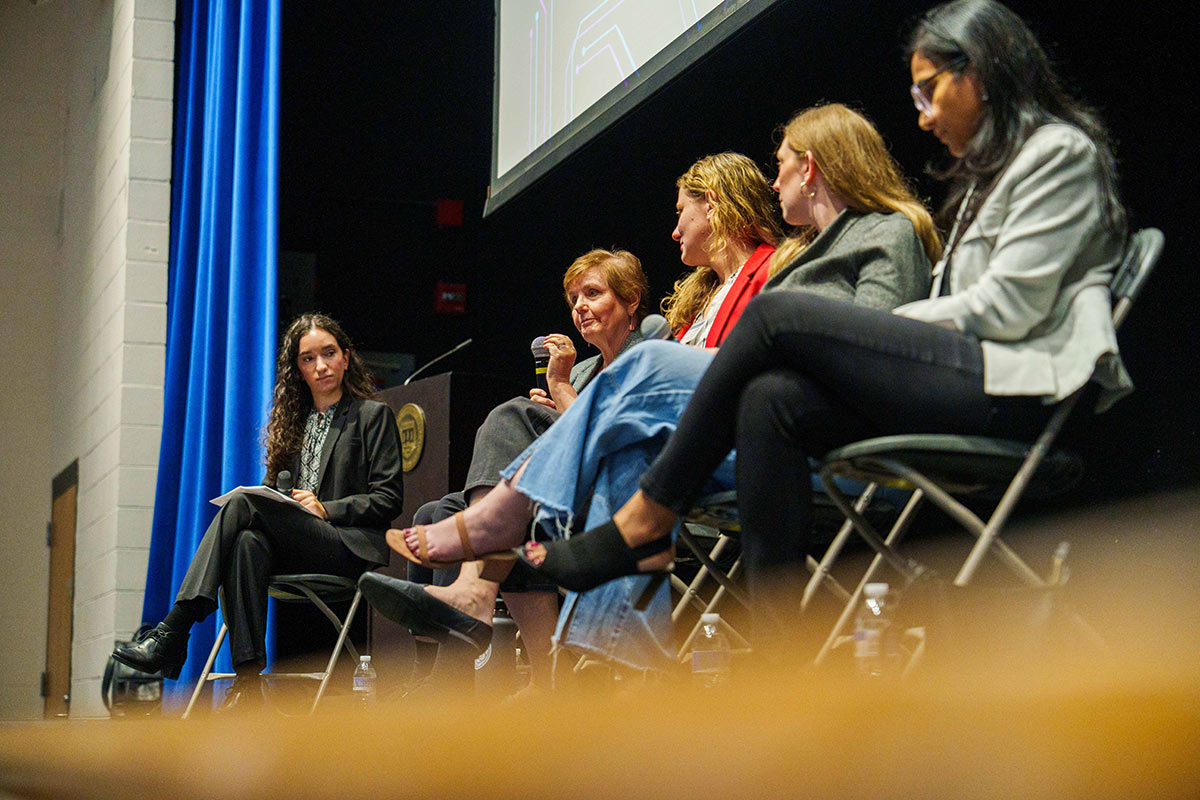A row of panelists on stage during an event