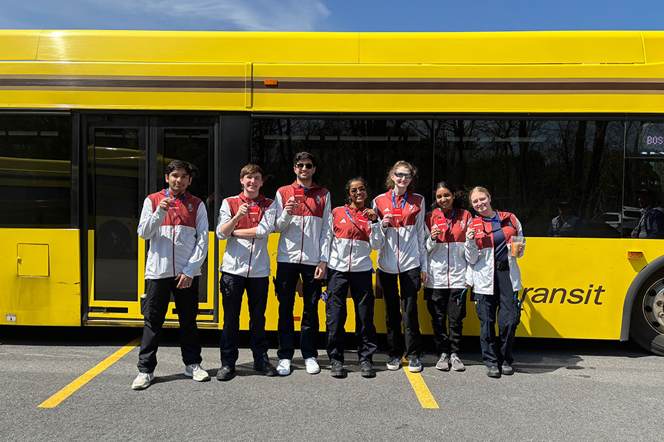 Students standing in front of a bus