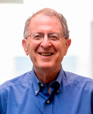 photo of a smiling gray-haired man with glasses