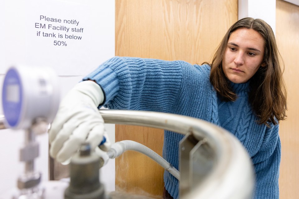 a student turns a knob on a liquid nitrogen tank