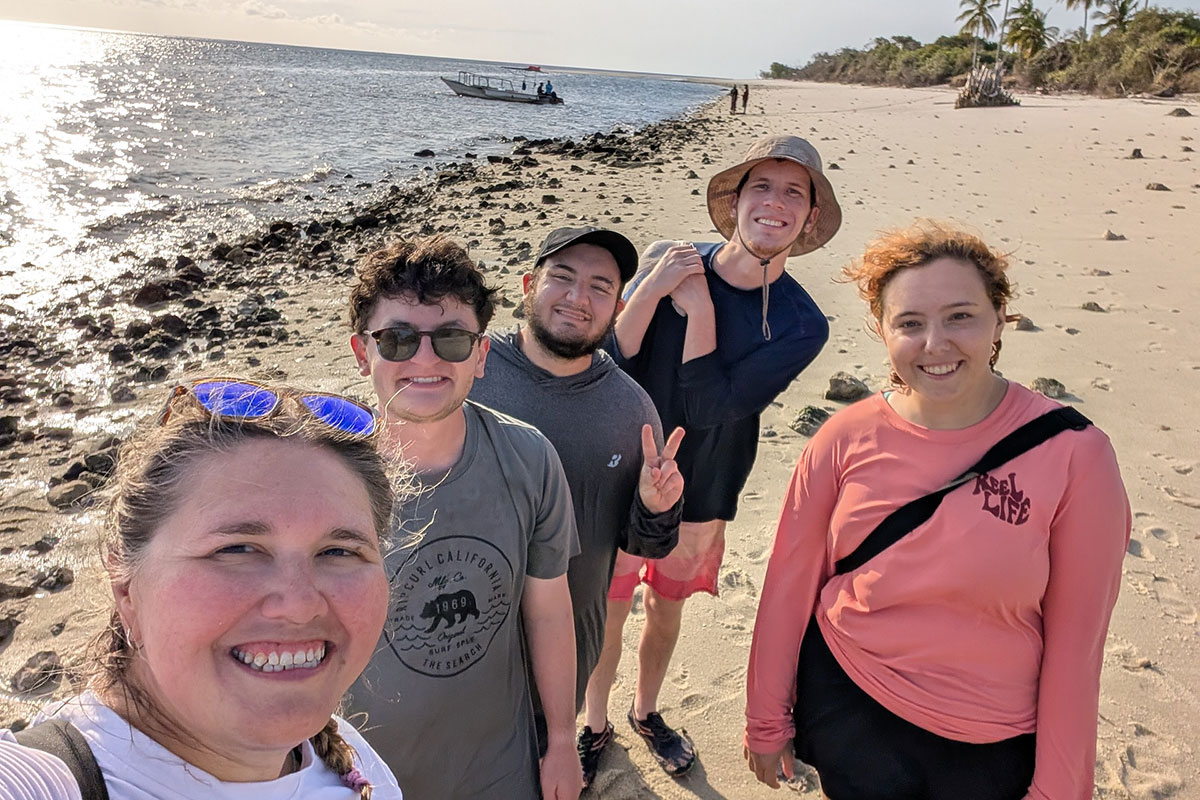 Alexandra Ratzlaff and her team of Brandeis undergraduates stand on the beach at Mafia Island.
