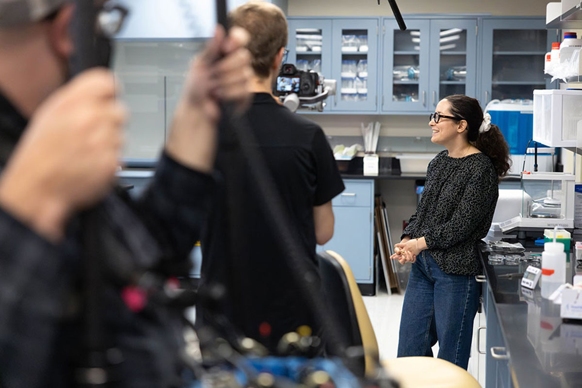 Hannah Yevick being interviewed in a lab.