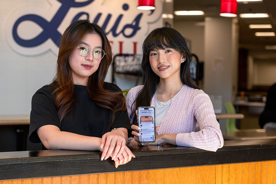 Two students holding a phone