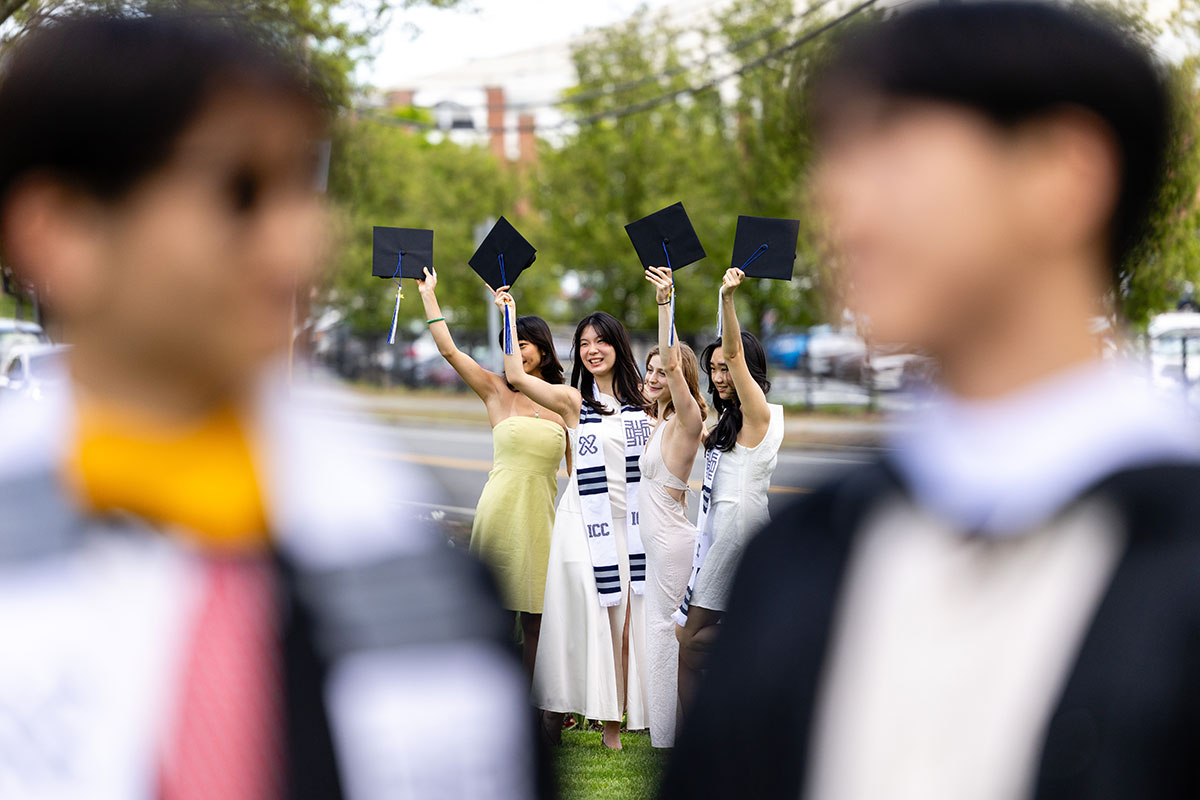 Students dressed in academic regalia pose for a group photo.