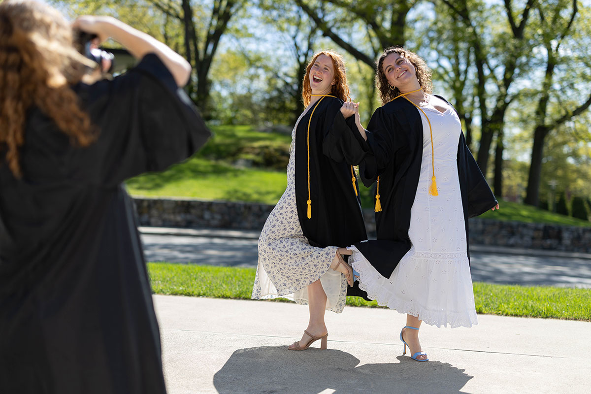 Two graduating students pose for a photo.