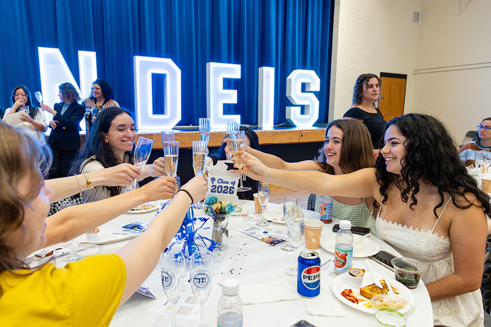 Students cheers with glasses on champagne at the Senior Toast Brunch. 