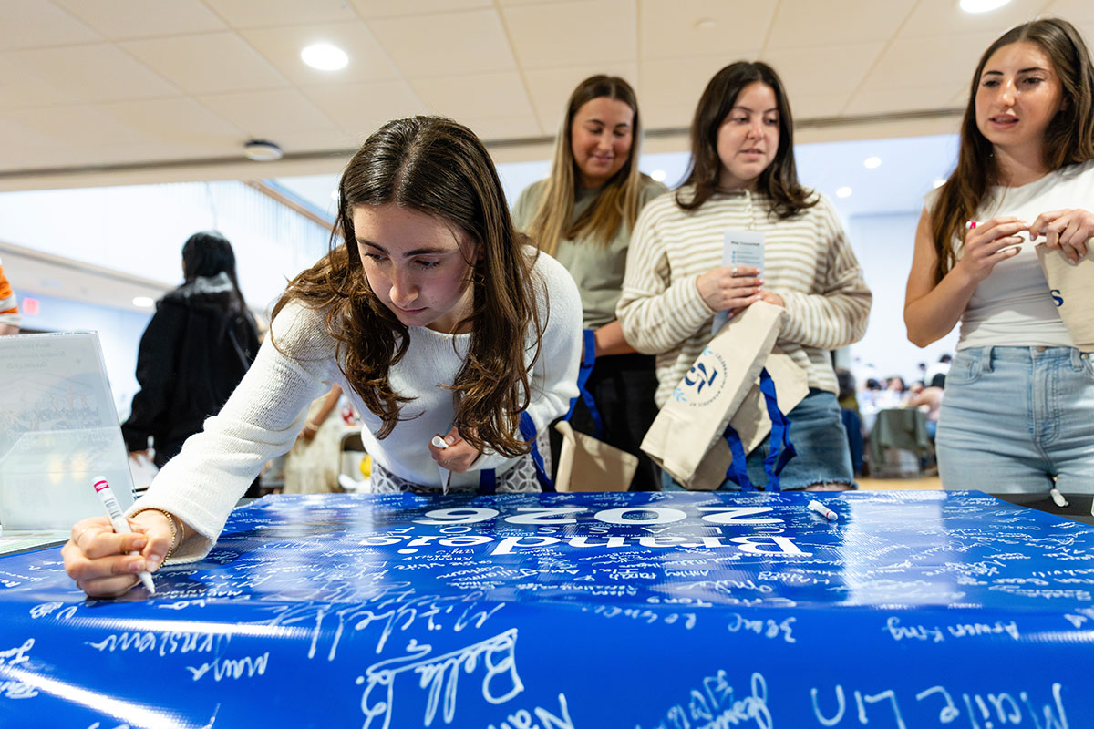 Students sign a banner with the words "Brandeis 2026"