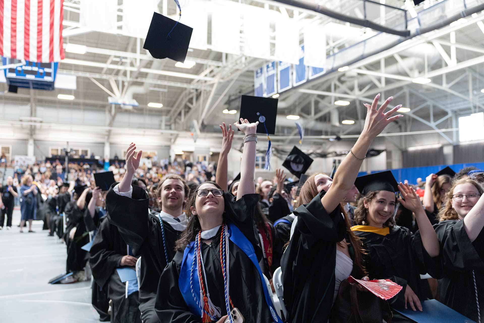 Graduates tossing caps in the air after Commencement