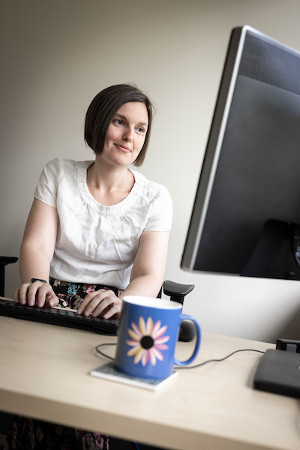 A photo of Jenny Crawford sitting at her desk.