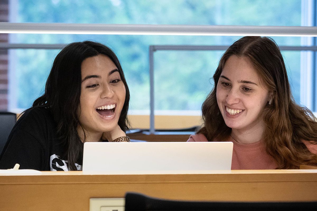 Students work together on a laptop