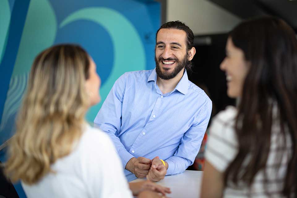 Eric Moyal talking with two other people