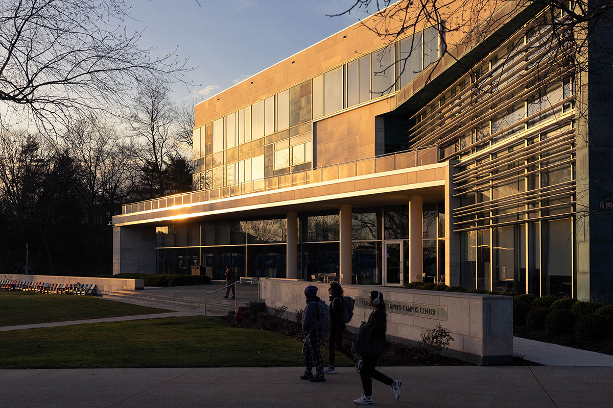 Students walk by the Shapiro Campus Center as the sun sets on campus.