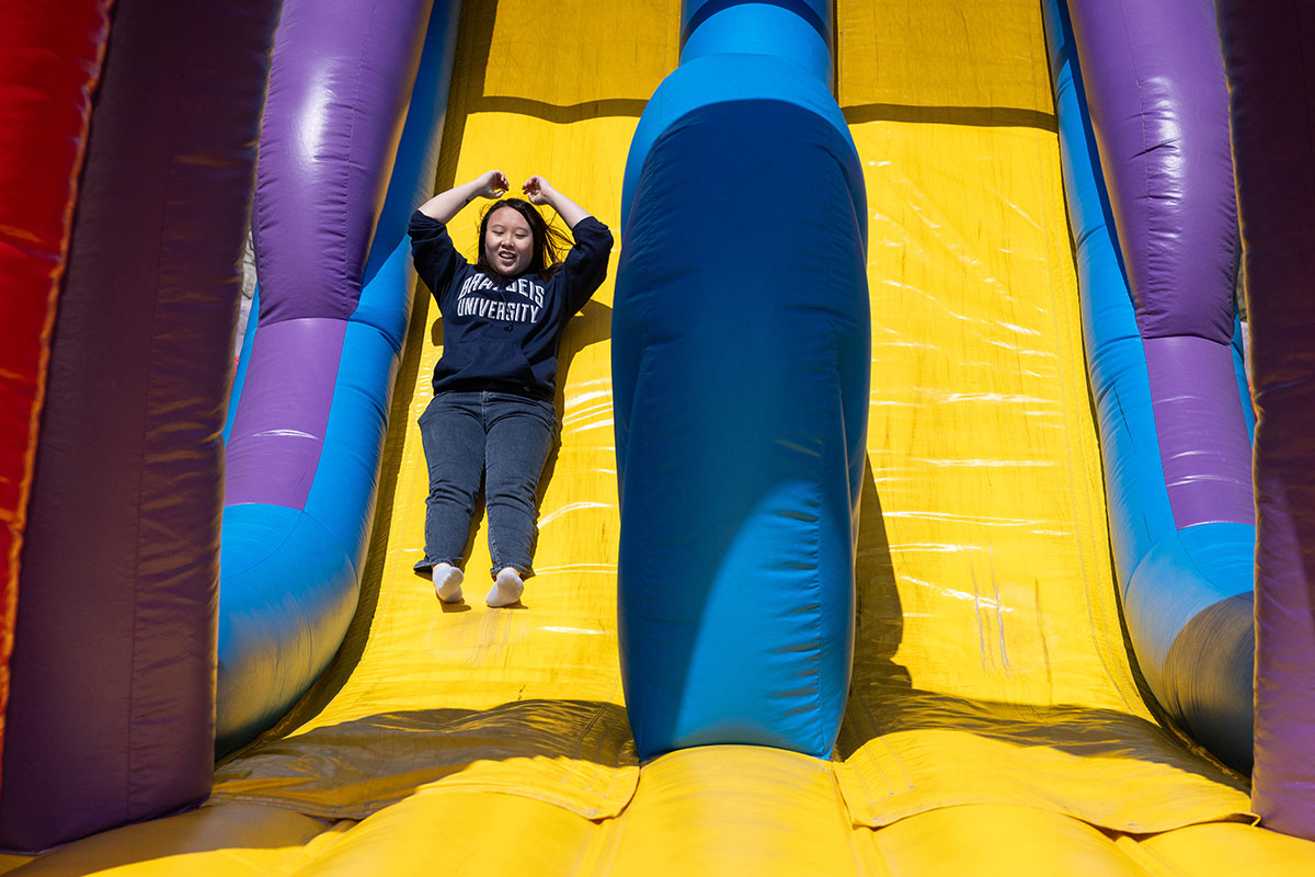 A student slides down an inflatable slide.